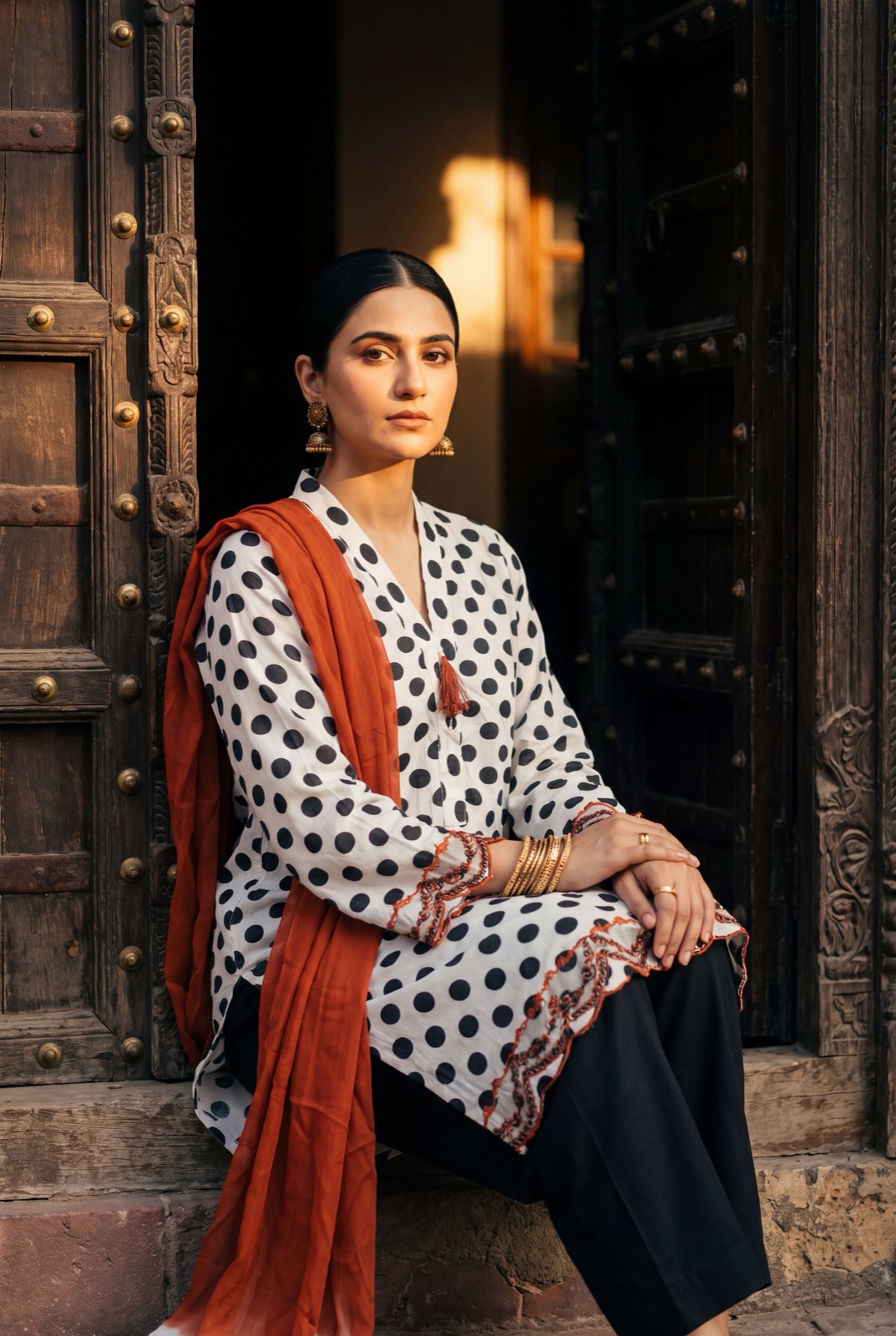 Black-on-white polka dot three-piece with rust chiffon dupatta and trousers